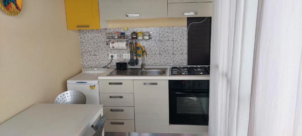 une petite cuisine avec un évier et une cuisinière dans l'établissement Villa Marzamemi Beach, à Marzamemi