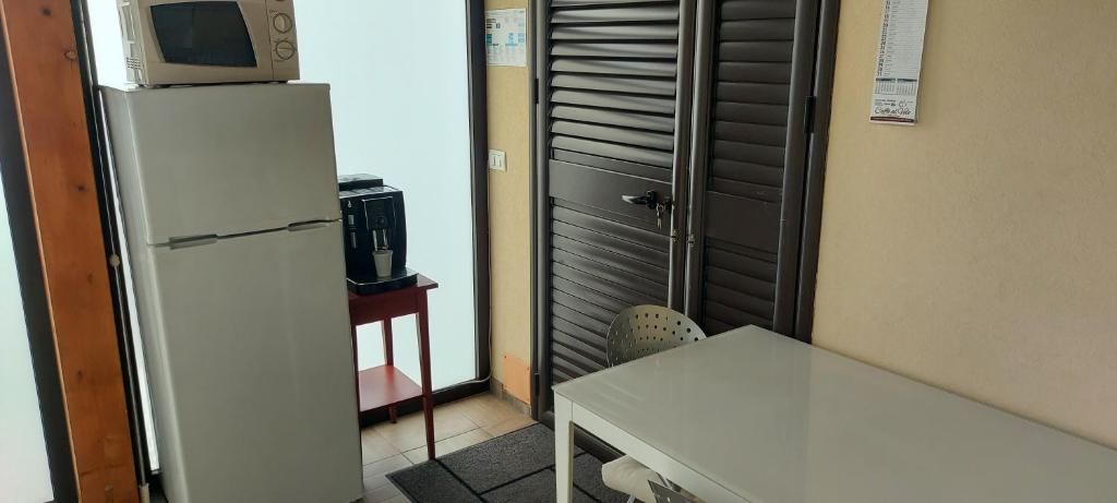 Il comprend une cuisine équipée d'un réfrigérateur et d'une table avec un four micro-ondes. dans l'établissement Villa Marzamemi Beach, à Marzamemi