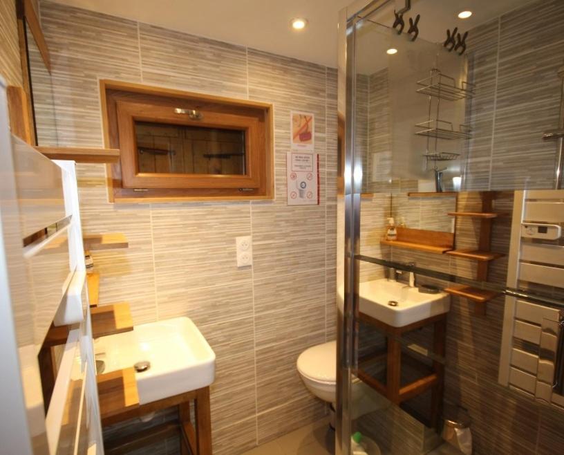 une salle de bain avec toilettes, lavabo et douche dans l'établissement Chalet Les Myrtilles aux Saisies, à Hauteluce