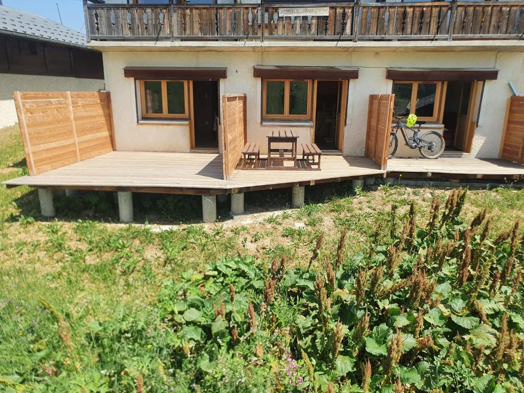 une maison avec une terrasse avec un vélo dessus dans l'établissement Chalet Les Myrtilles aux Saisies, à Hauteluce