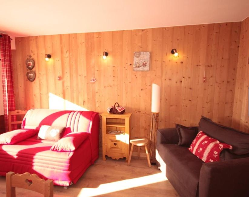un salon avec un canapé et une chaise dans l'établissement Chalet Les Myrtilles aux Saisies, à Hauteluce