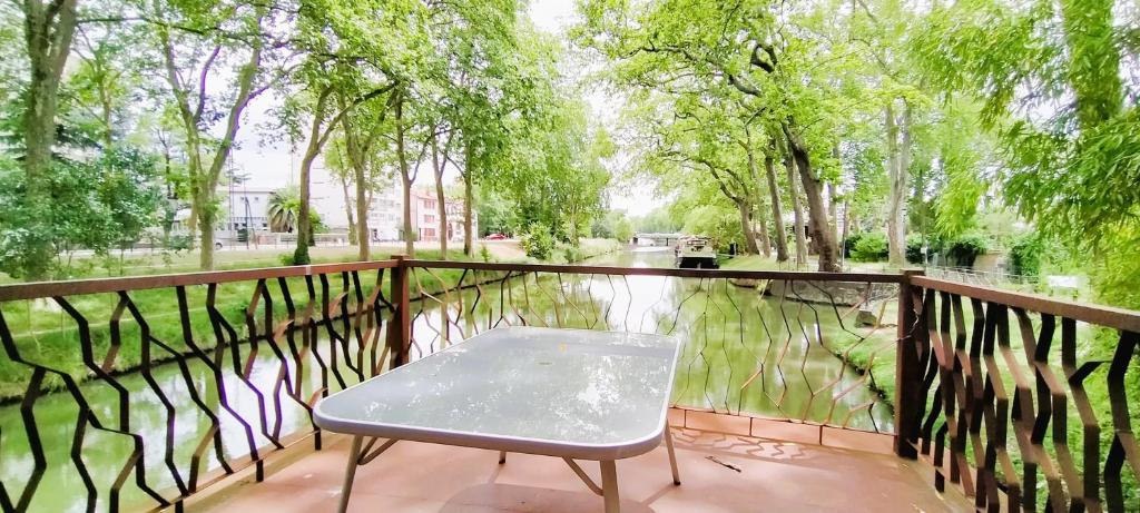 une chaise sur un balcon à côté d'un plan d'eau dans l'établissement Péniche Kairos - Havre de paix sur Canal du midi, à Toulouse 6 autres photos