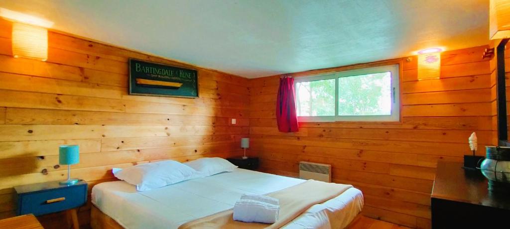 - une chambre avec un lit blanc dans un mur en bois dans l'établissement Péniche Kairos - Havre de paix sur Canal du midi, à Toulouse