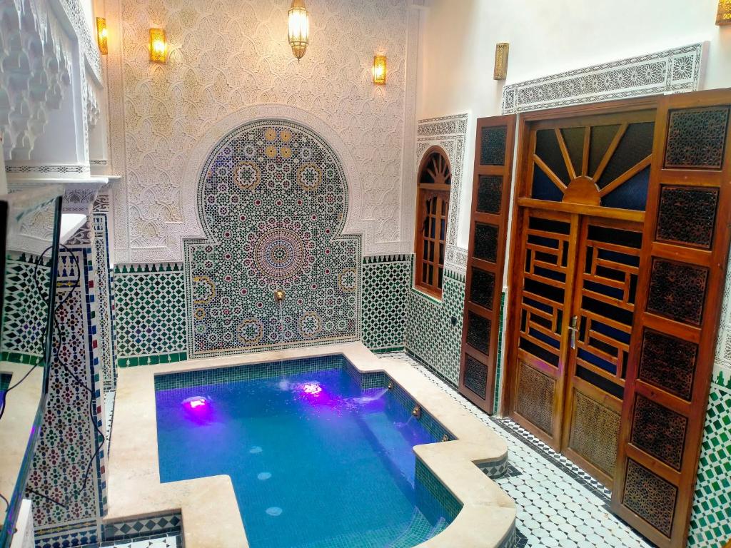 une piscine dans une pièce avec un mur carrelé dans l'établissement Riad Diamant Bleu, à Fès