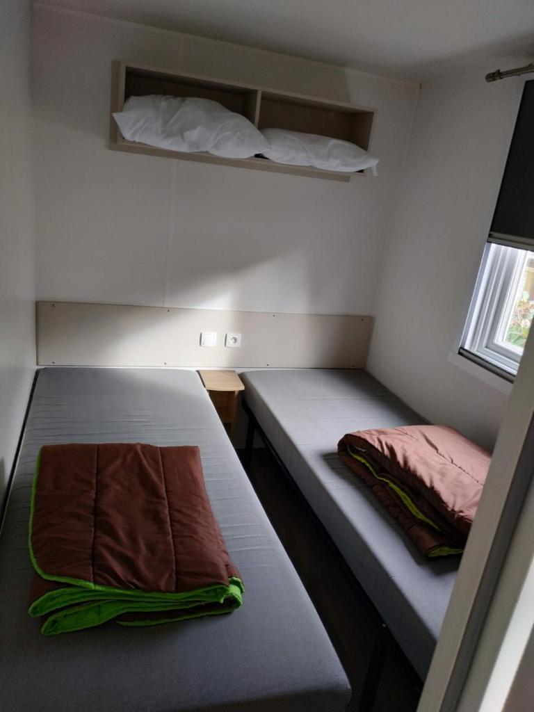 une petite chambre avec deux lits et une fenêtre dans l'établissement repos merite, à Gastes