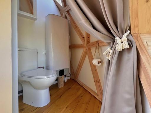 La salle de bains est pourvue de toilettes et d'un rideau. dans l'établissement Dôme Pathome, à Catonvielle