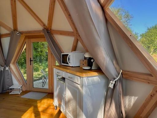 une cuisine avec une cuisinière et un micro-ondes dans une maison dans l'établissement Dôme Pathome, à Catonvielle