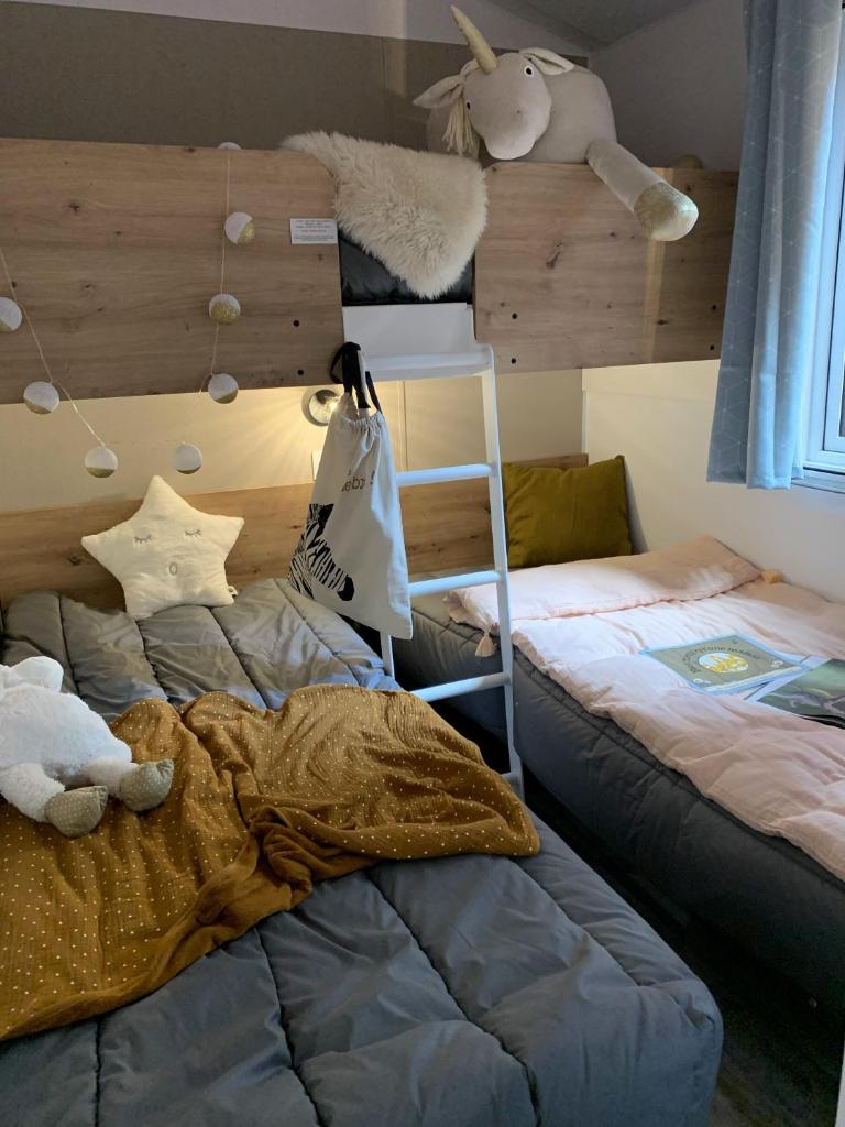 une chambre avec deux lits, une échelle et une étagère dans l'établissement BAHIA LUXE, à Limeuil