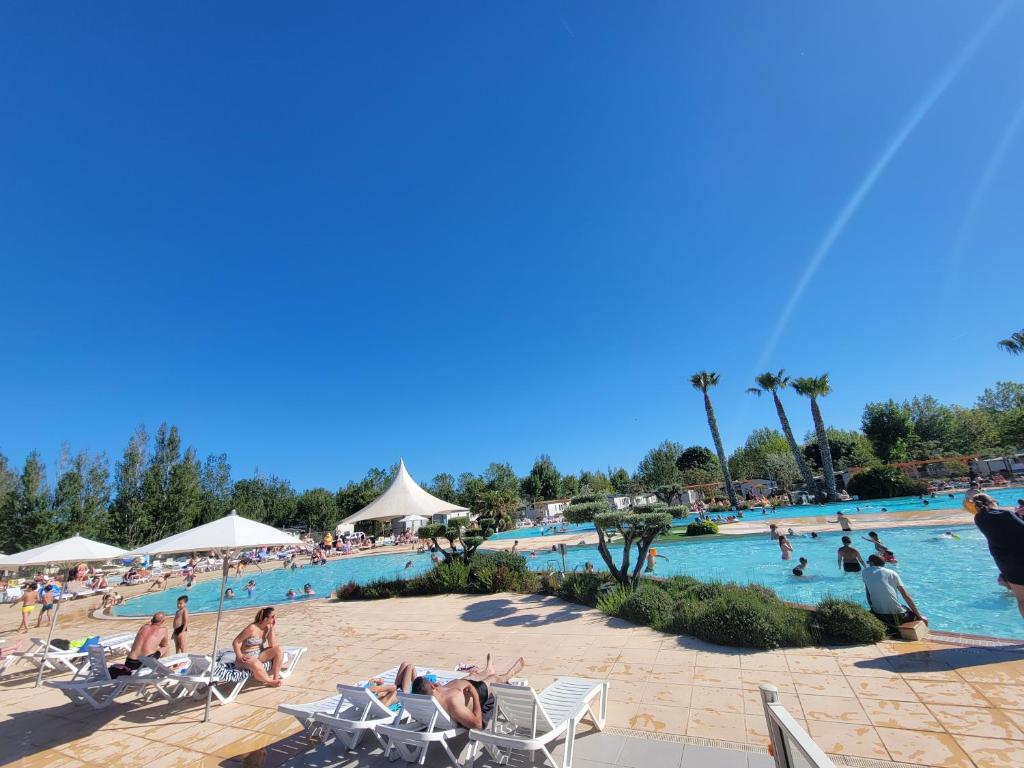 un groupe de personnes dans une piscine d'un complexe hôtelier dans l'établissement Superbe mobile home neuf - Mazet 71 - Camping la Carabasse, à Vias