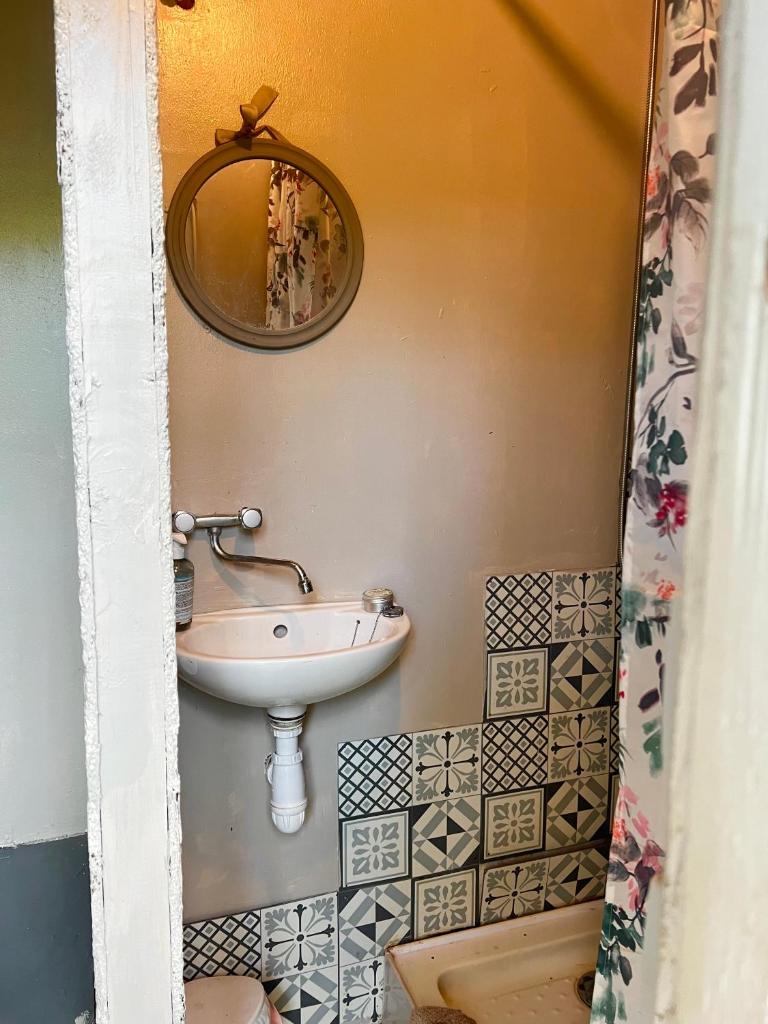 une salle de bain avec un lavabo et un miroir au mur dans l'établissement Tente lodge en pleine nature, à Sumène