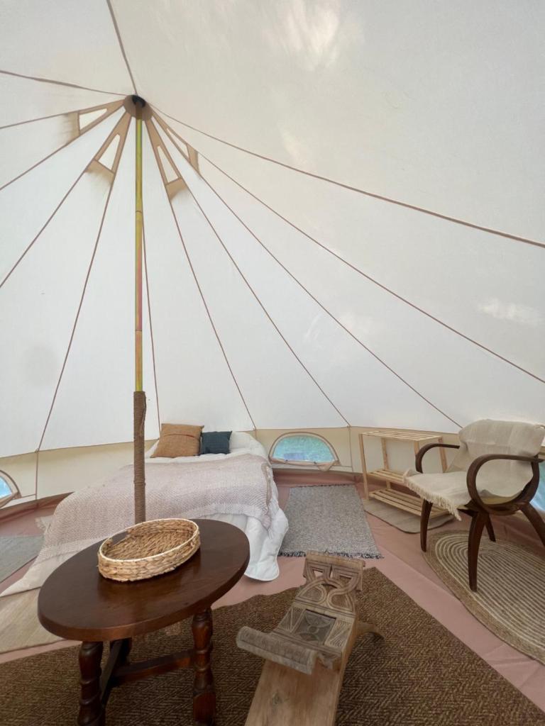 Cette chambre comprend une tente avec une table et une chaise. dans l'établissement Tente lodge en pleine nature, à Sumène