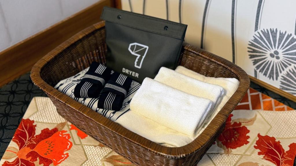 un panier avec des serviettes et un sac dessus dans l'établissement Yufuin Akarinoyado, à Yufu 37 autres photos