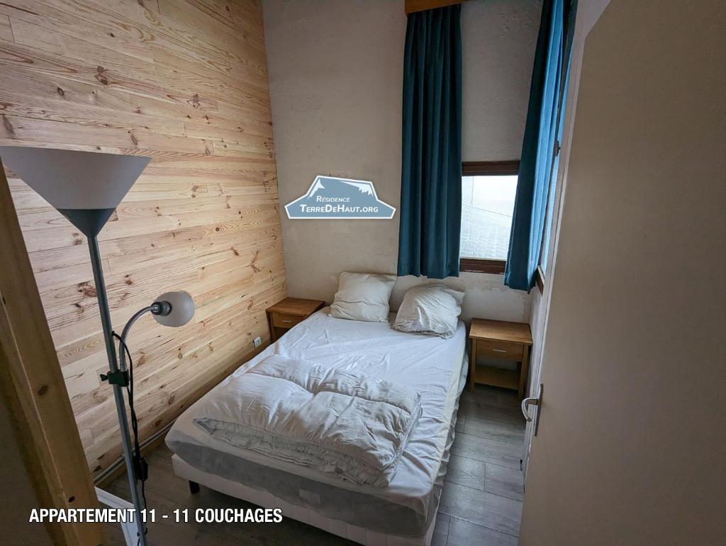 une petite chambre avec un lit et une fenêtre dans l'établissement Résidence Terre de Haut, à Super-Besse