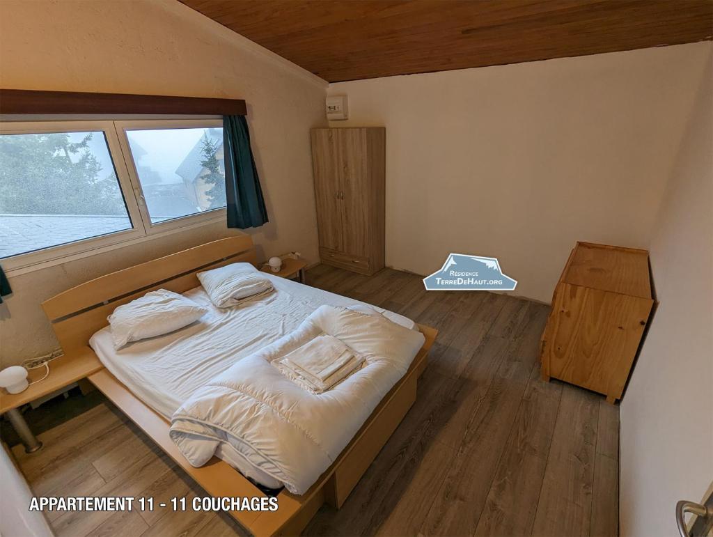 une petite chambre avec un lit et une fenêtre dans l'établissement Résidence Terre de Haut, à Super-Besse