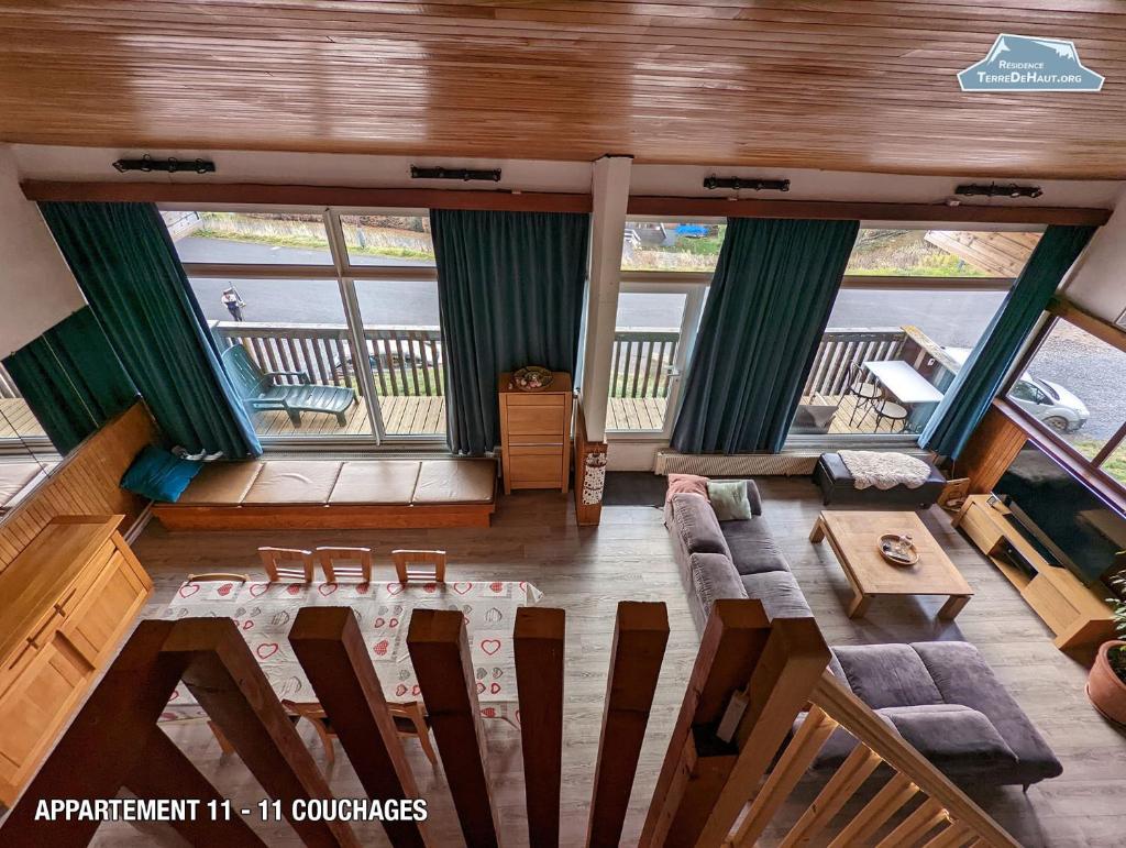 une vue aérienne d'un salon avec un canapé et une table dans l'établissement Résidence Terre de Haut, à Super-Besse