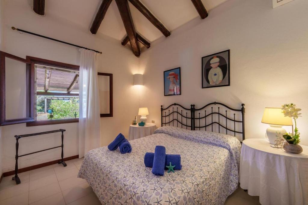 - une chambre avec 2 lits dotés d'oreillers bleus dans l'établissement VILLA VELA MARINA, à Santa Teresa Gallura
