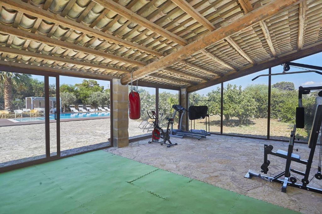 - une salle de sport avec vue sur la piscine dans l'établissement Villa Maraus by PosarelliVillas, à Marausa