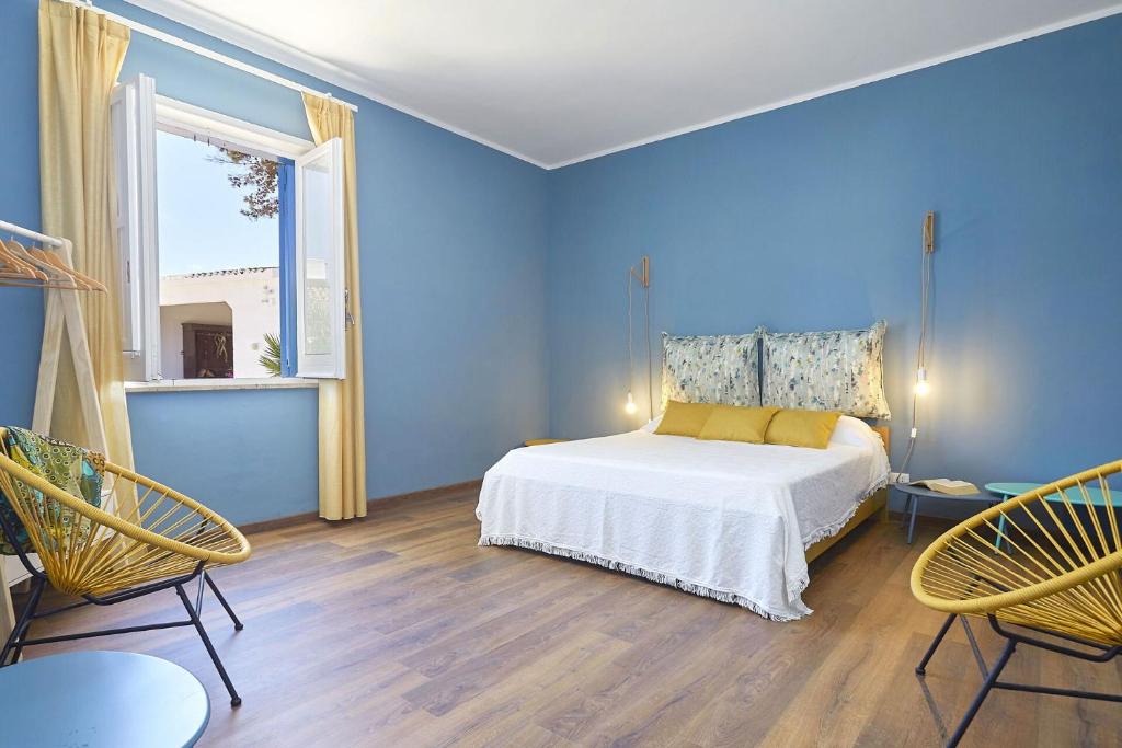 - une chambre bleue avec un lit et deux chaises dans l'établissement Villa Maraus by PosarelliVillas, à Marausa 55 autres photos