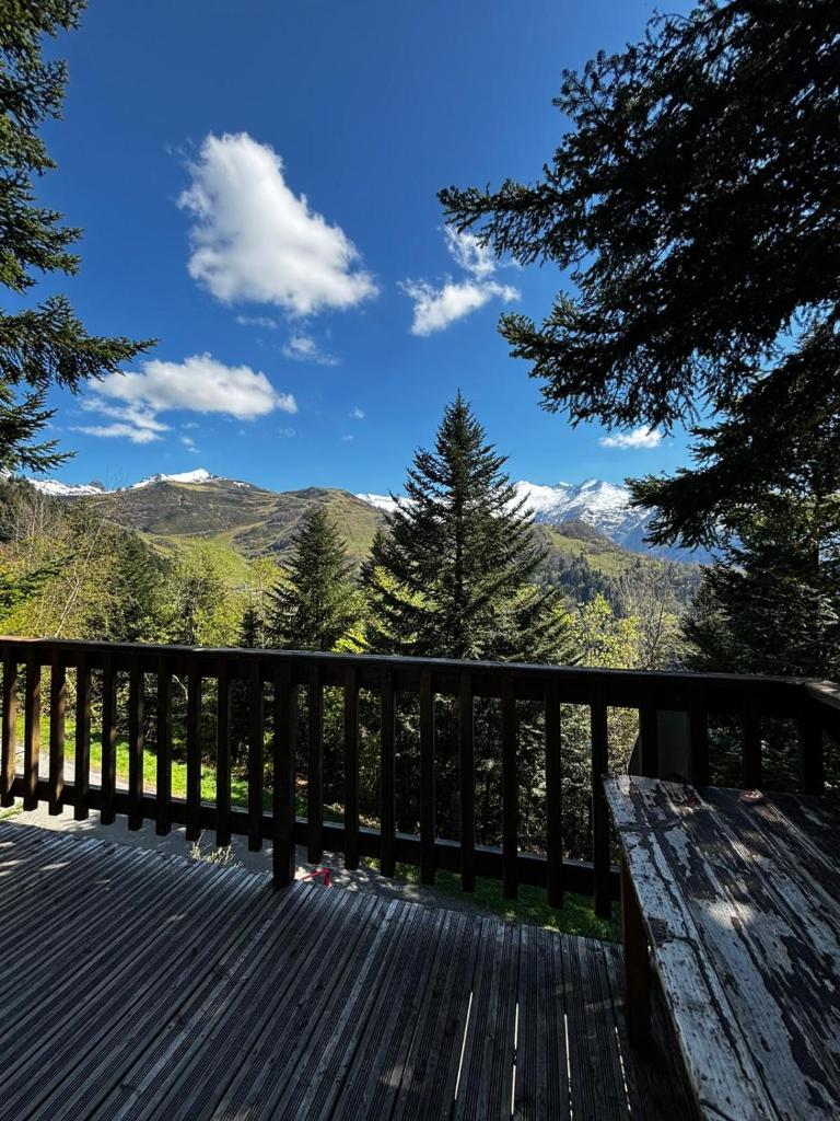 - un banc en bois sur une terrasse avec vue sur les montagnes dans l'établissement Chalet de montagne, à Ustou