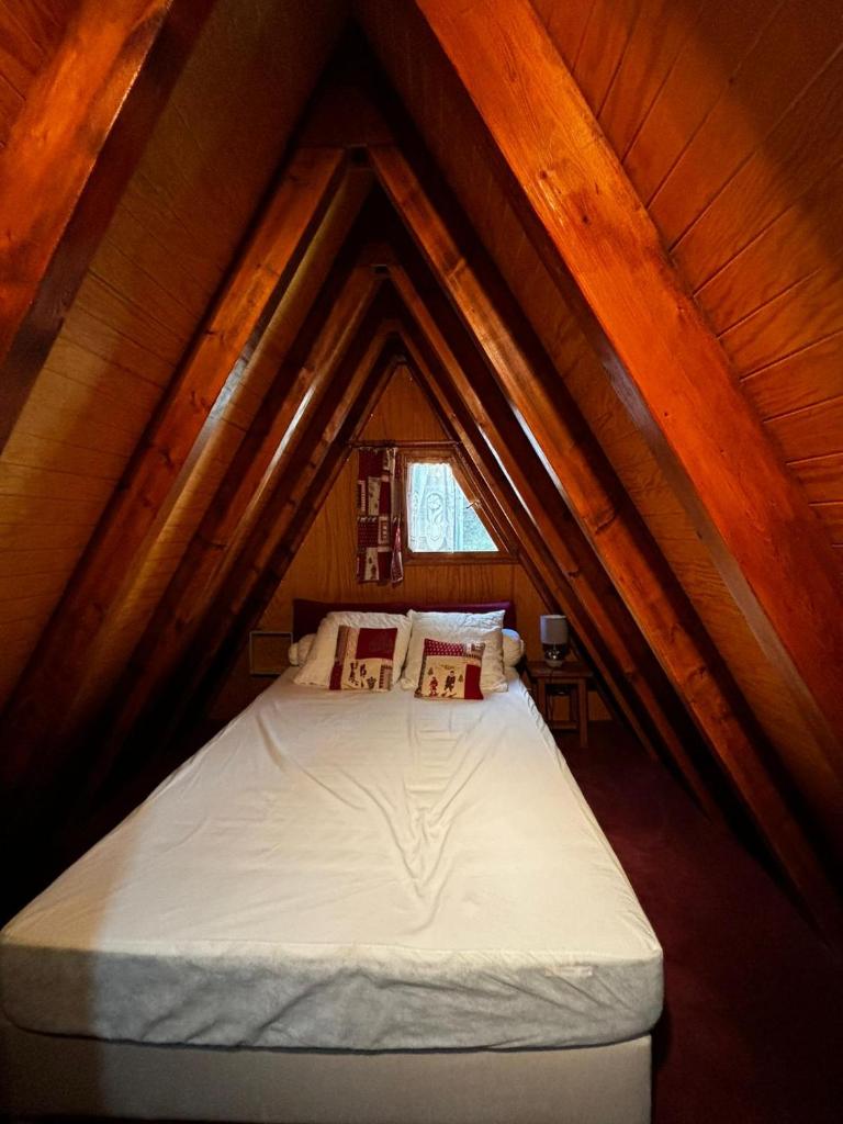 une chambre avec un lit dans un grenier dans l'établissement Chalet de montagne, à Ustou 19 autres photos