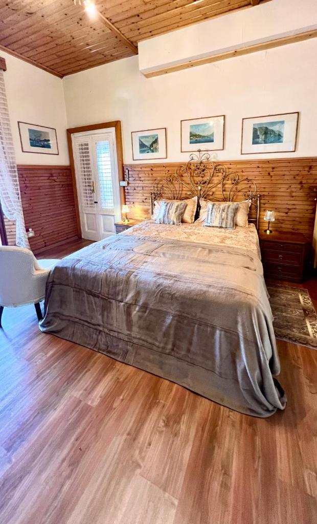 une chambre avec un grand lit et un parquet dans l'établissement Villa Andreina Como Lake, à Moltrasio