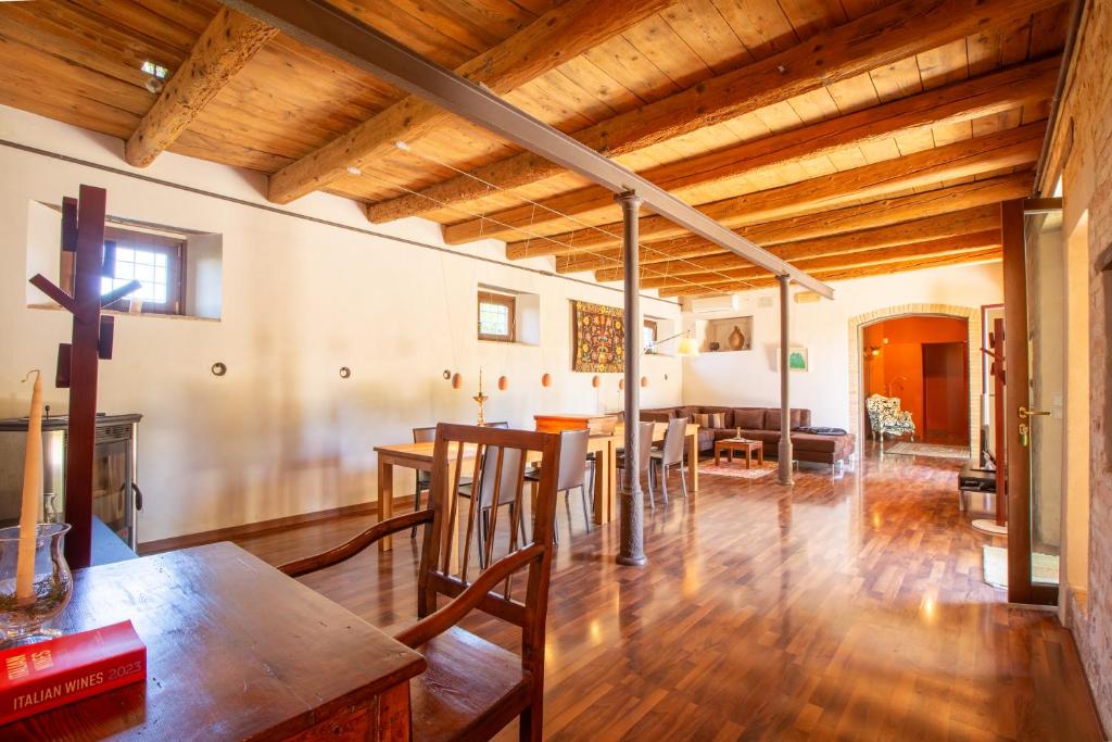 - une salle à manger et un salon avec un plafond en bois dans l'établissement Villa Gelso - Tenuta esclusiva con piscina, sauna e vista panoramica, à Belvedere Ostrense
