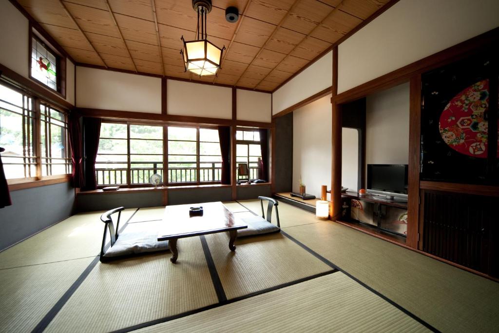 - un salon avec une table dans une pièce dotée de fenêtres dans l'établissement Hatago Kayausagi, à Hita 30 autres photos