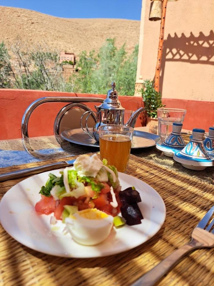 - une assiette de nourriture sur une table avec une bouilloire dans l'établissement DAR DANI café restaurant, à Boumalne
