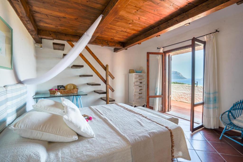 une chambre avec un grand lit et un escalier dans l'établissement Villa Azzurra , piscina, parcheggio e vista mare, à Porto Istana