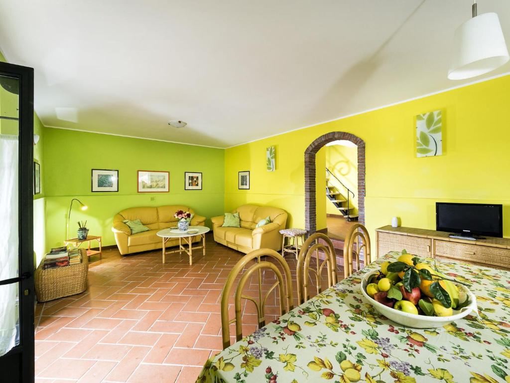 un salon avec des murs jaunes et une table avec un bol de fruits dans l'établissement Villa Idyllica, à Gaggi