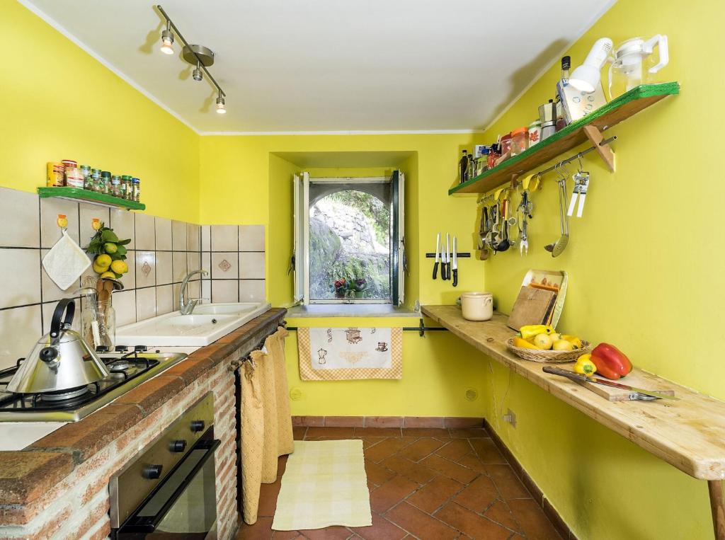 une cuisine avec des murs jaunes et un comptoir. dans l'établissement Villa Idyllica, à Gaggi