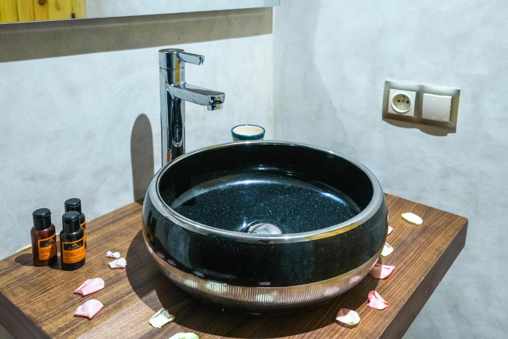 un lavabo noir dans une salle de bain avec des coeurs roses dans l'établissement Riad Babette, à Essaouira