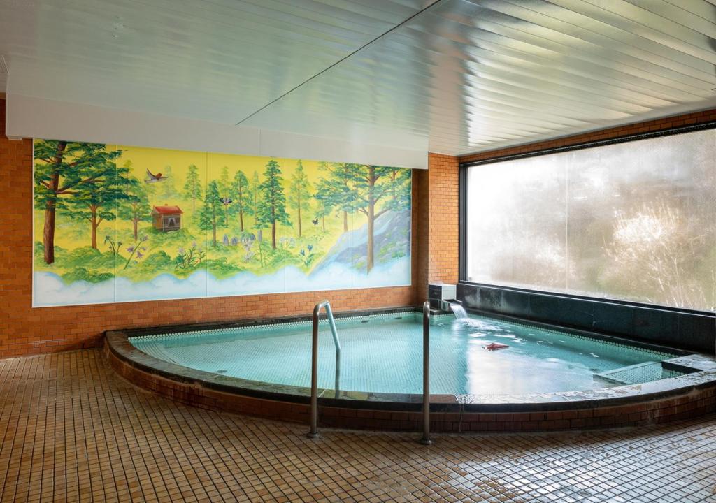 - une grande piscine dans un bâtiment orné d'une peinture dans l'établissement Morino Hotel, à Kiso