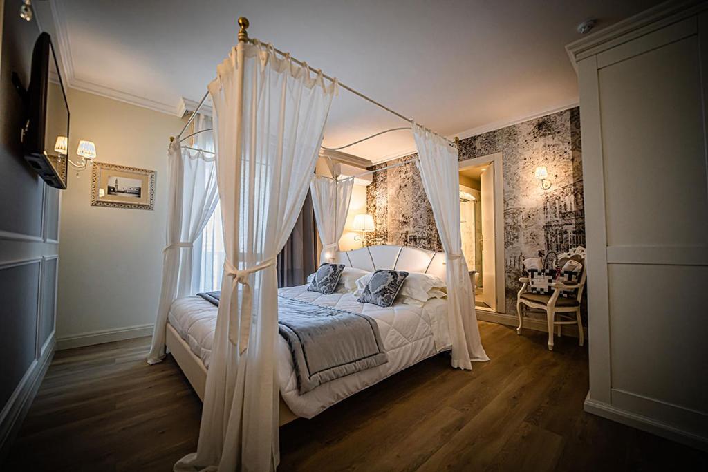 une chambre avec un lit à baldaquin avec des rideaux blancs dans l'établissement Hotel Ca' D'Oro Tre Stelle Superior Adults only, à Bibione 103 autres photos