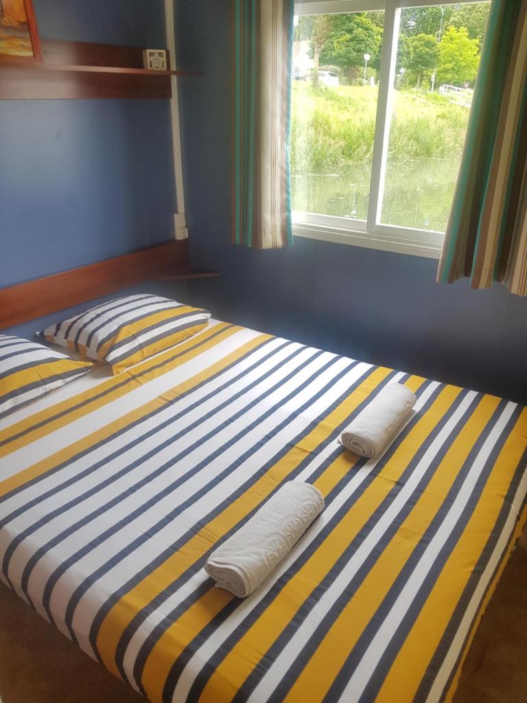 - un lit avec 2 oreillers et une fenêtre dans l'établissement Cottage flottant Terrasse Nature près Dijon, à Ouges