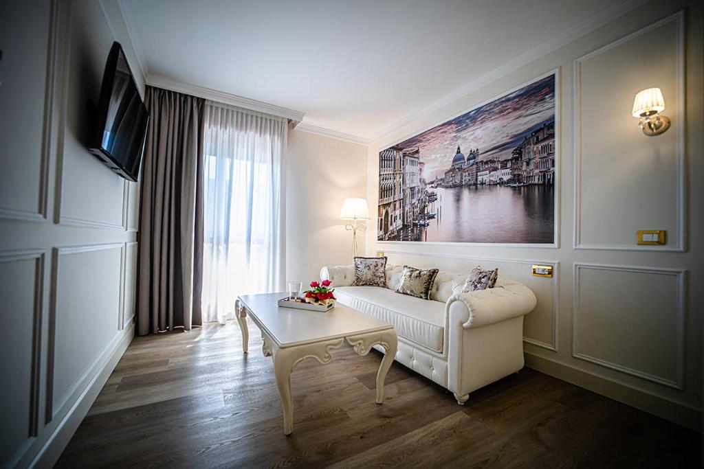 un salon avec un canapé et une table dans l'établissement Hotel Ca' D'Oro Tre Stelle Superior Adults only, à Bibione
