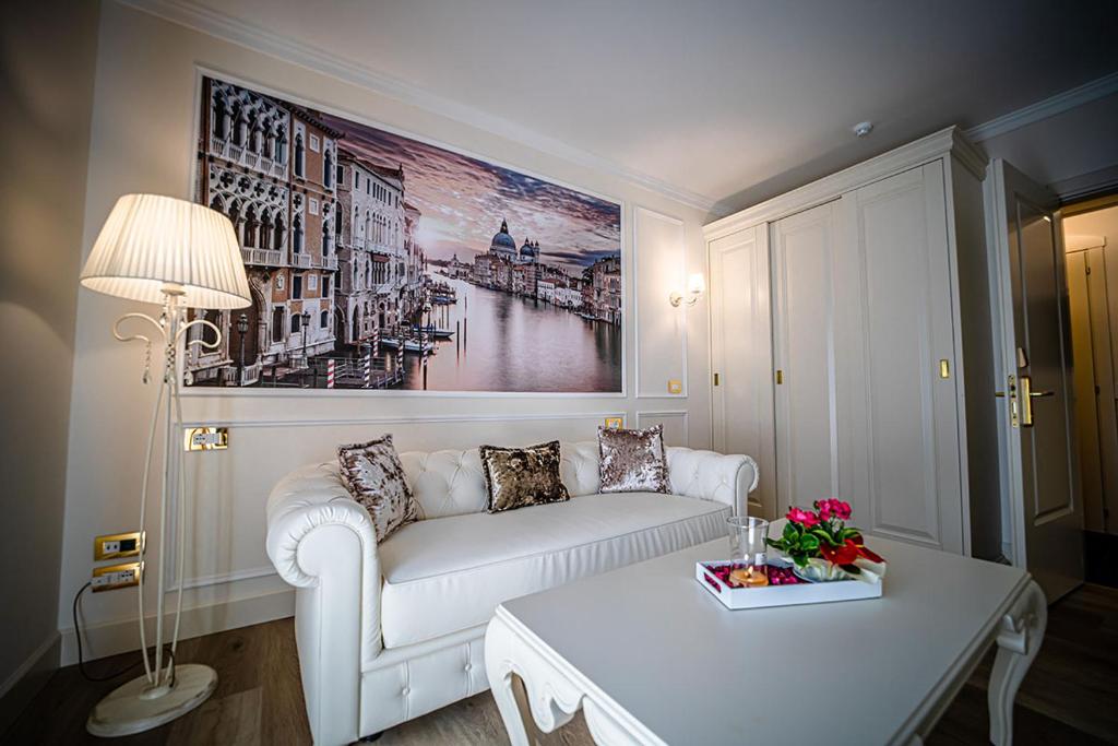 un salon avec un canapé blanc et une table dans l'établissement Hotel Ca' D'Oro Tre Stelle Superior Adults only, à Bibione