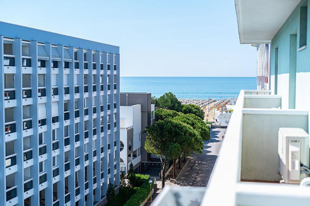 d'un balcon offrant une vue sur un bâtiment et l'océan. dans l'établissement Hotel Ca' D'Oro Tre Stelle Superior Adults only, à Bibione