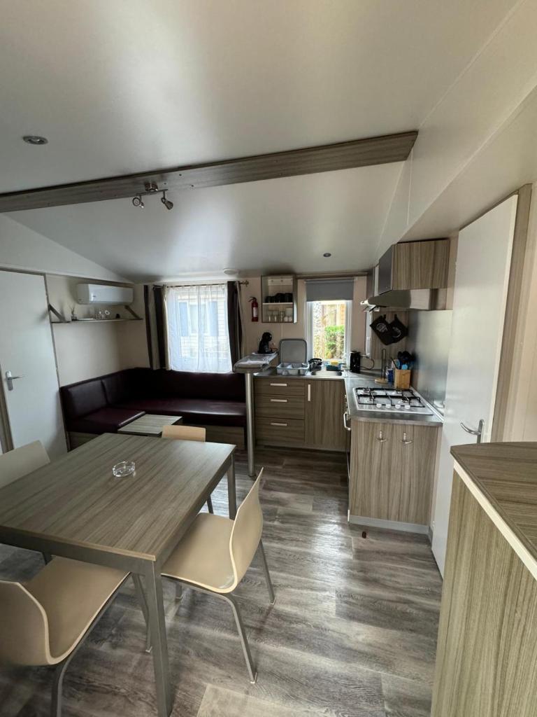 une cuisine et un salon avec une table et des chaises dans l'établissement Mobil-home bord de mer, à Vendres