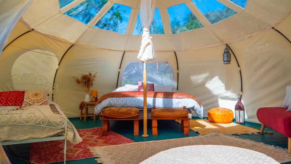 une chambre avec un lit dans une tente dans l'établissement Les Cabanes d'ErbeFol, à Ansignan