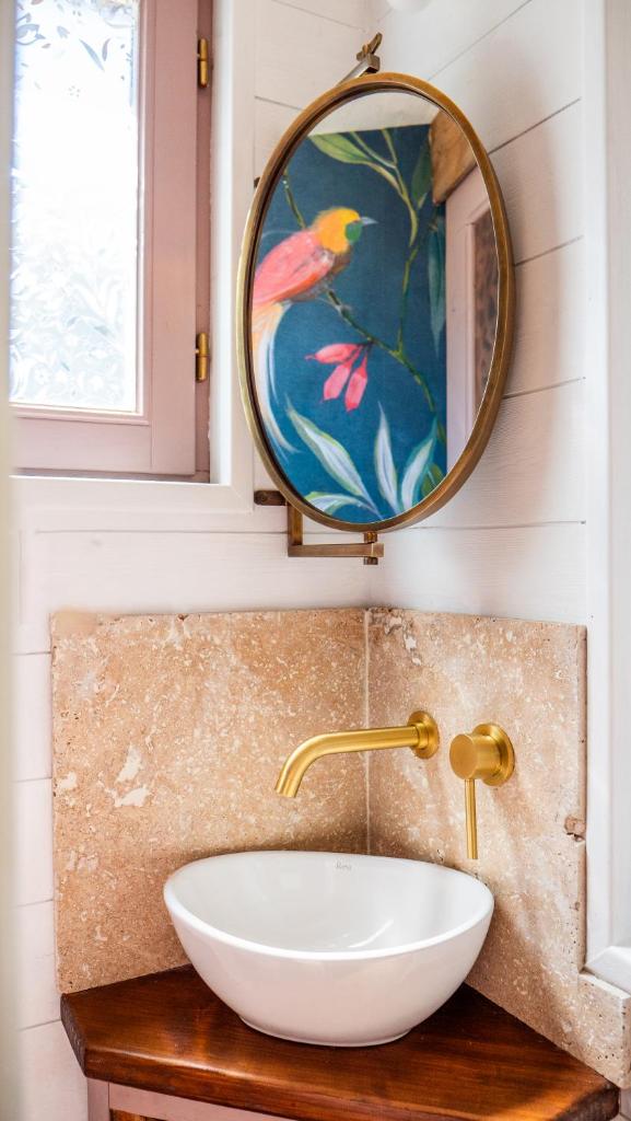 une salle de bain avec un lavabo blanc et un miroir dans l'établissement Les Cabanes d'ErbeFol, à Ansignan