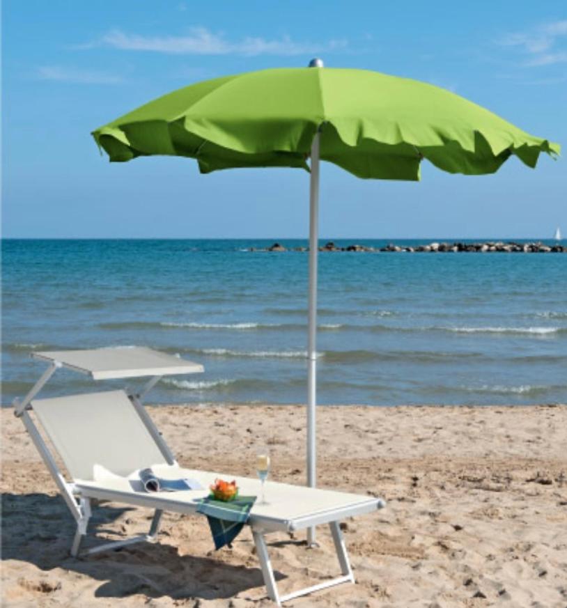 - un parasol vert et une chaise sur la plage dans l'établissement Hotel Migani, à Rimini