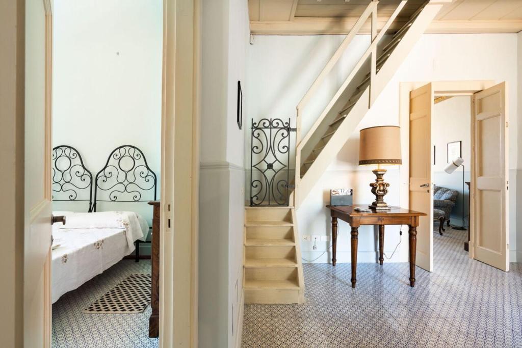 - une chambre avec un lit et un escalier avec une table dans l'établissement Villa Voces, à Catane