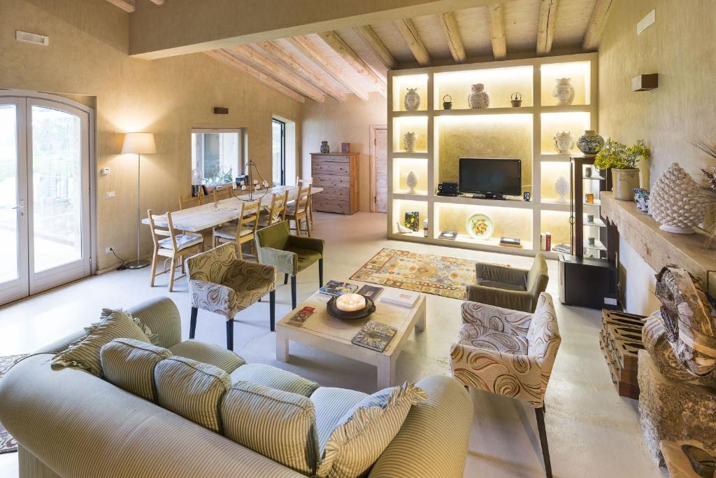 un salon avec des canapés et une table ainsi qu'une salle à manger dans l'établissement Villa Madera, à Caltagirone