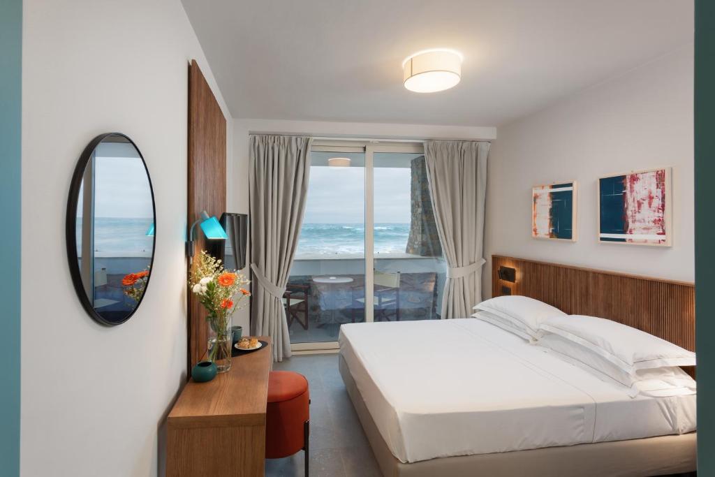 une chambre avec un lit, un miroir et une fenêtre dans l'établissement Hotel Arc En Ciel, à Diano Marina 107 autres photos