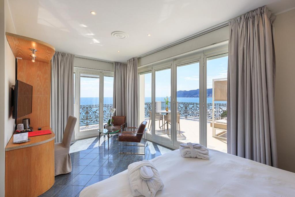 une chambre d'hôtel avec un lit et un balcon dans l'établissement Grand Hotel Mediterranee, à Alassio