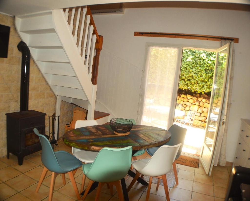 une salle à manger avec une table et des chaises et un escalier dans l'établissement La Rose des Vents & Spa - Gite Savane, à Néoules
