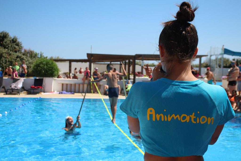 une femme dans une piscine tenant une corde dans l'établissement Camping La Brise de Camargue, à Saintes-Maries-de-la-Mer