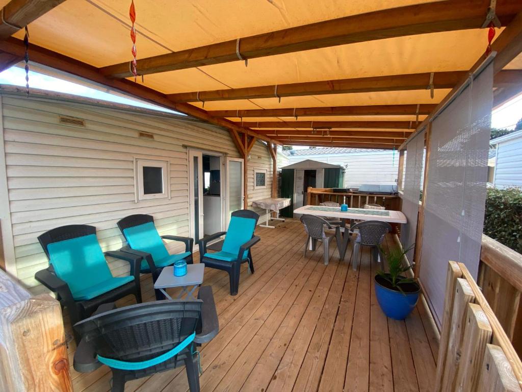 un patio avec des chaises et une table sur une terrasse dans l'établissement Mobil home de charme à la mer, à Fréjus