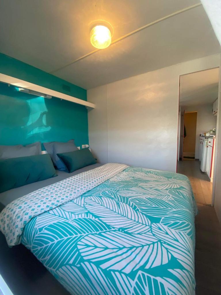une chambre avec un lit avec une couette bleue et blanche dans l'établissement Mobil home de charme à la mer, à Fréjus 9 autres photos